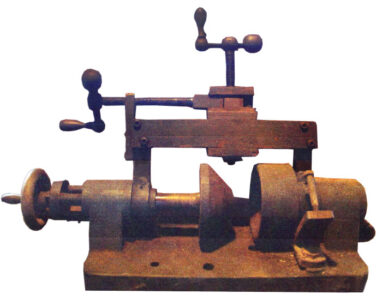 rusted tool with two cranks and a wheel